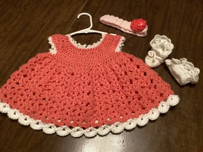 Handmade coral crochet doll dress with white scalloped trim, matching rose headband and white booties