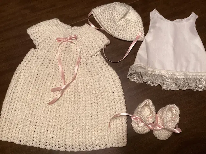 Cream crochet doll gown with pink ribbon, matching bonnet, lace slip and booties