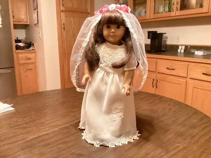 18-inch doll wearing a handmade ivory bridal gown, veil and flower crown